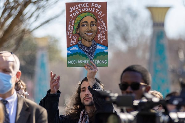 FILE - Noah Gringi holds a sign at a press conference for Manuel Esteban Paez Terán in Decatur, Ga., Feb. 6, 2023. (Arvin Temkar/Atlanta Journal-Constitution via AP, File)