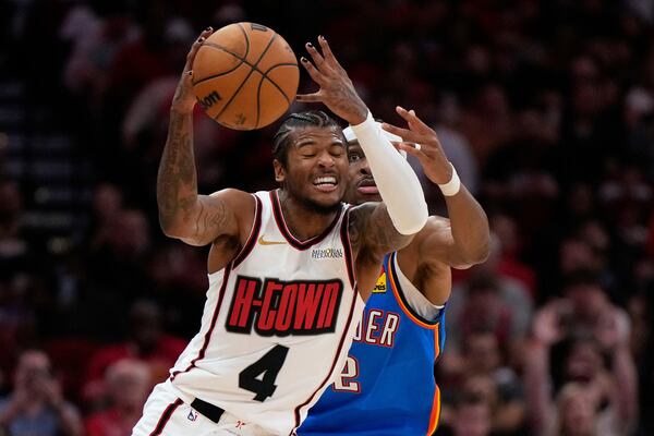 Houston Rockets guard Jalen Green (4) and Oklahoma City Thunder guard Shai Gilgeous-Alexander (2) try to take control of a loose ball during the first half of an NBA basketball game in Houston, Friday, April 4, 2025. (AP Photo/Ashley Landis)