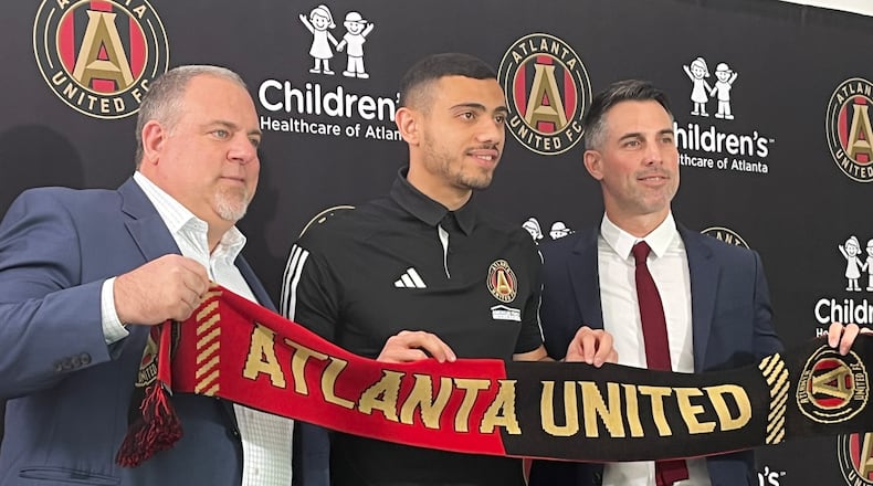 Atlanta United President Garth Lagerwey, Giorgos Giakoumakis and Vice President Carlos Bocanegra pose on Friday at the introduction of the player. (Doug Roberson/The Atlanta Journal-Constitution)