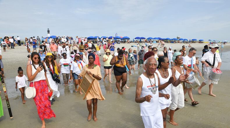 Hundreds of gatherers head into the water during Tybee Island Juneteenth Celebration.
