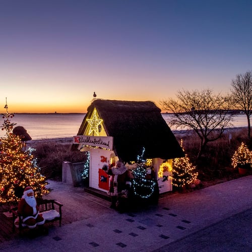 FILE - Christmas trees and Santa Clauses decorate the entrance to the beach in Haffkrug, northern Germany, Monday, Dec. 20, 2021. (Photo/Michael Probst, File)