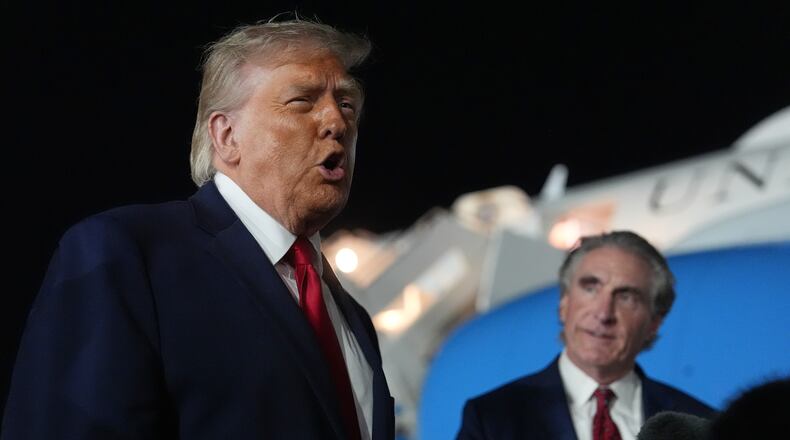 President Donald Trump talks with reporters before boarding Air Force One at John F. Kennedy International Airport in New York, early Tuesday, June 9, 2026, as Interior Secretary Doug Burgum listens. (AP Photo/Mark Schiefelbein)