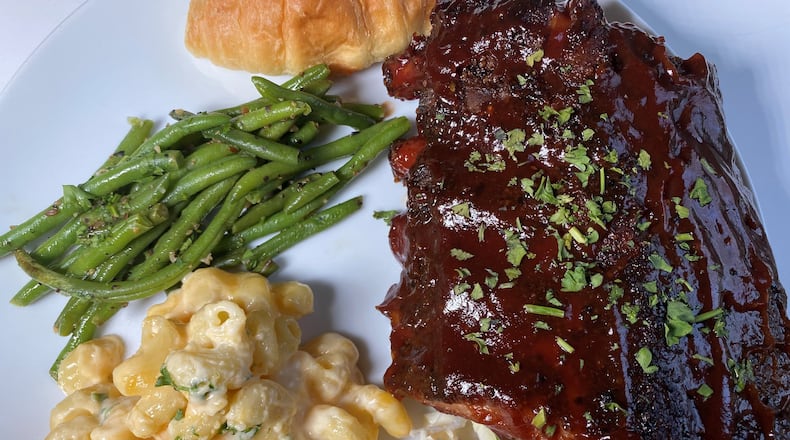 This Big Oak Tavern family meal includes baby back ribs, coleslaw, macaroni and cheese, green beans and dinner rolls. Bob Townsend for The Atlanta Journal-Constitution