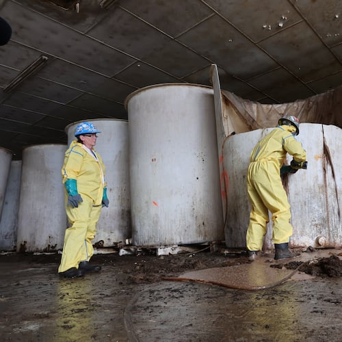 Sludge pours out of a vat of fermenting fish sauce in an abandoned fish sauce factory in St. Mary's, N.L., on Tuesday July 28, 2026. (Elling Lien/The Canadian Press via AP)