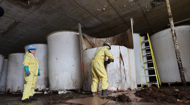 Sludge pours out of a vat of fermenting fish sauce in an abandoned fish sauce factory in St. Mary's, N.L., on Tuesday July 28, 2026. (Elling Lien/The Canadian Press via AP)