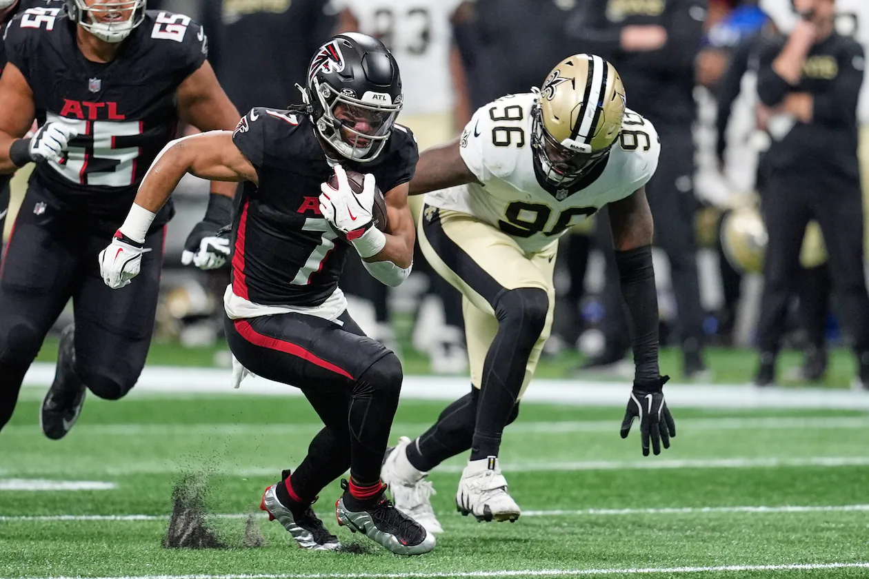 Atlanta Falcons running back Bijan Robinson (left) carries past New Orleans Saints defensive end Carl Granderson in the first half of an NFL game, Sunday, Jan. 4, 2026, in Atlanta. (Mike Stewart/AP)