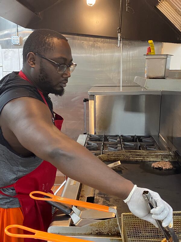 Jalen Mitchell, son of owner Conchitha Hargrove, operates the grill and fryer at VFC Kitchens, a virtual food court in Jonesboro. Ligaya Figueras/ligaya.figueras@ajc.com
