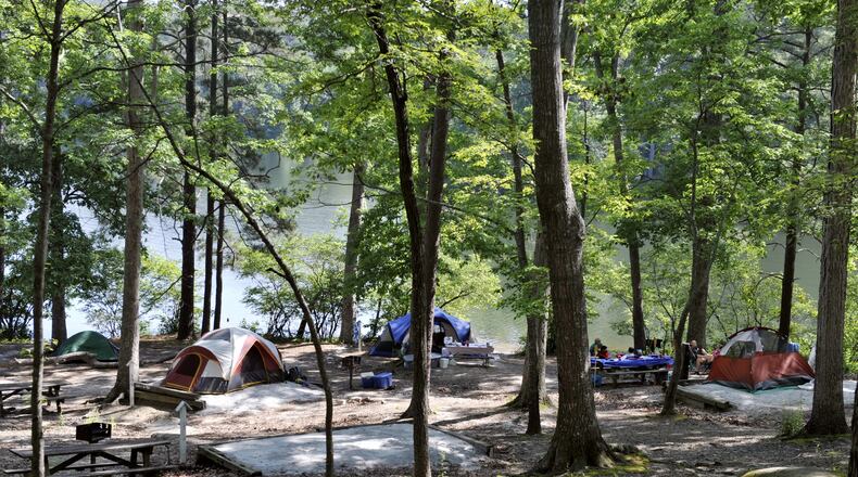 Campers pitch their tents in the woods by the lake at Stone Mountain Park in this 2010 photo. Stone Mountain Park recently added three new yurts nestled lakeside in the park’s popular campground. The new homes away from home are made of wood and canvas, featuring outside decks, picnic tables, charcoal grills, a fire pit and large water spigots for camping convenience. Inside each yurt, comfort awaits in the form of log furniture, heat and AC, electric outlets, large windows, skylights, ceiling fans, lockable doors and sleeping space for up to five guests. All a camper needs to bring is a sleeping bag or linens and personal items. AJC FILE PHOTO