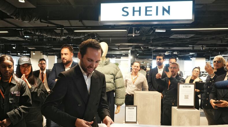 The director of the Bazar de l'Hotel de Ville (BHV) department store Karl-Stephane Cottendin cuts the ribbon at the opening Shein's first physical store in Paris, Wednesday, Nov. 5, 2025. ( Dimitar Dilkoff, Pool via AP)