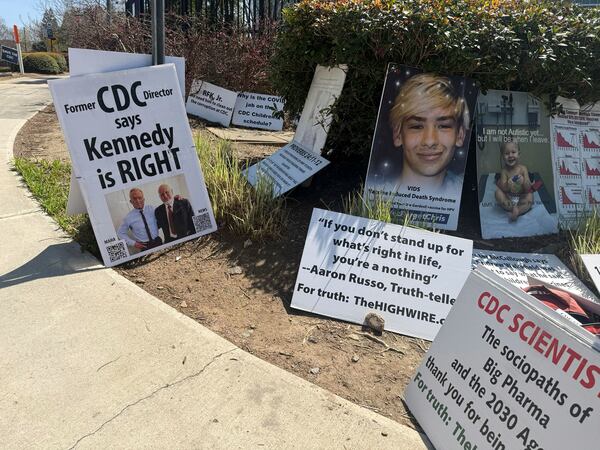 Signs placed by Mike Arnold, a supporter of Health Secretary Robert F. Kennedy Jr., are pictured as Arnold protests against the CDC outside the CDC campus in Atlanta, Thursday, March 27, 2025. (AP Photo/Kenya Hunter)