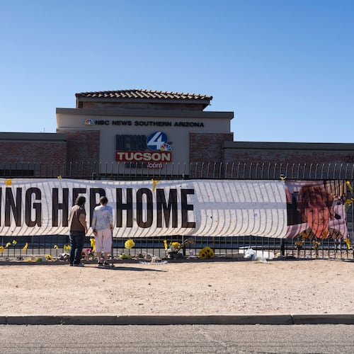 FILE - People visit a banner for Nancy Guthrie, the missing mother of "Today" show host Savannah Guthrie, outside the KVOA Newsroom in Tucson, Ariz., on March 6, 2026. (AP Photo/Rebecca Noble, File)