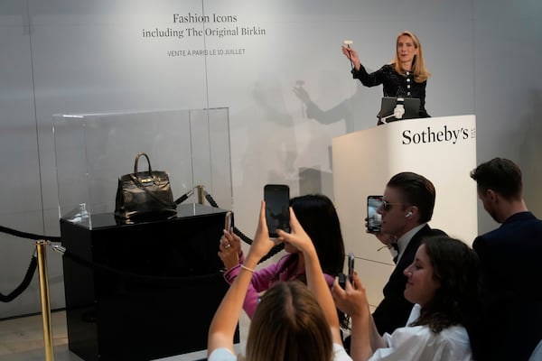 Auction officer Aurélie Vandevoorde gestures as the original Birkin bag created by Hermès for Jane Birkin was sold at auction for 7 million euros or $8.2 million, Thursday, July 10, 2025 in Paris. (AP Photo/Michel Euler)