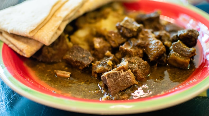 The bone-in curry goat combination meal with warm roti at Tassa Roti Shop in Marietta. CONTRIBUTED BY HENRI HOLLIS