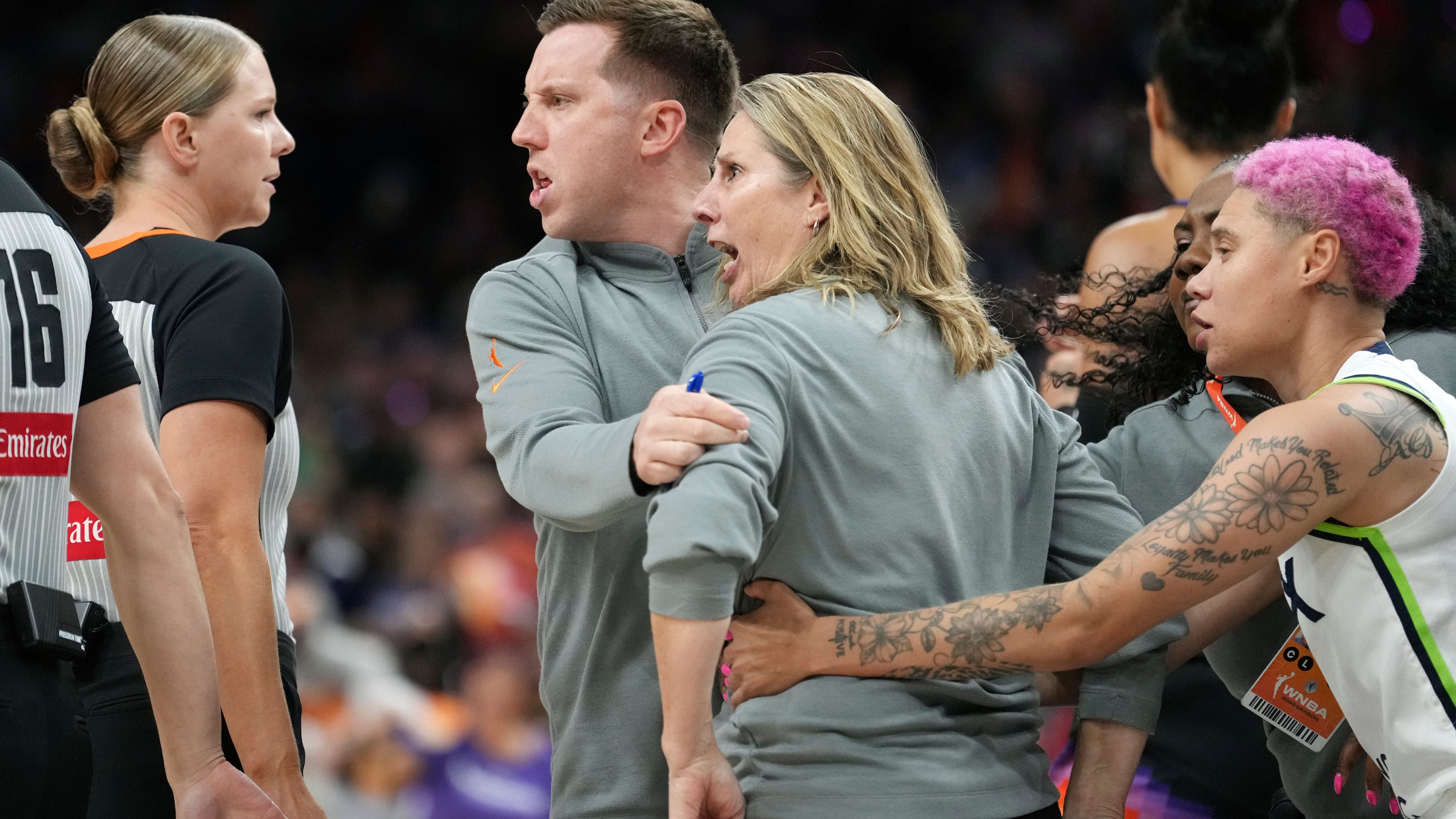 Minnesota Lynx head coach Cheryl Reeve, second from right, yells at officials as she is restrained by Lynx associate head coach Eric Thibault, center, and Lynx guard Natisha Hiedeman, right, after being ejected after earning a second technical foul during the second half of Game 3 of a WNBA basketball playoff semifinals series game against the Phoenix Mercury Friday, Sept. 26, 2025, in Phoenix. (AP Photo/Ross D. Franklin)