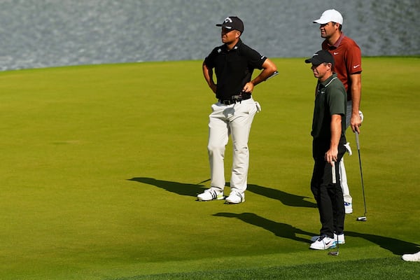 Xander Schauffele, Rory McIlroy, of Northern Ireland, and Scottie Scheffler line up a their putts on the 14th hole during the first round of the PGA Championship golf tournament at the Quail Hollow Club, Thursday, May 15, 2025, in Charlotte, N.C. (AP Photo/David J. Phillip)