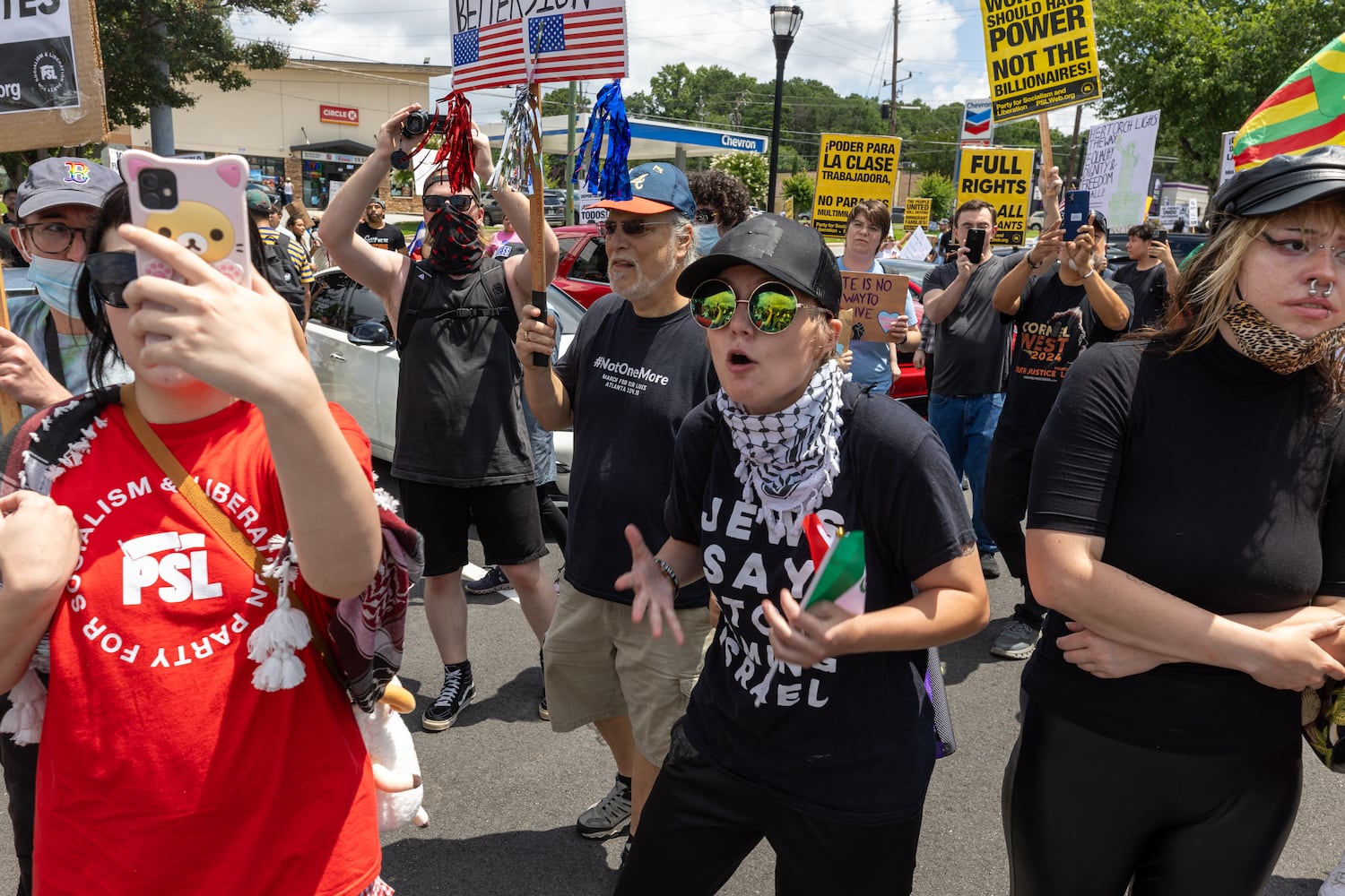 Demonstrators chant at police during a protest on ICE raids and deportation arrests on Chamblee-Tucker Road in Atlanta on Saturday, June 14, 2025. (Arvin Temkar / AJC)