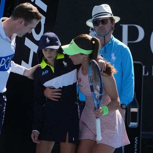 Zeynep Sonmez of Turkey and umpire Chase Urban help a ball kid who fainted, from the court during her first round match against Ekaterina Alexandrova of Russia at the Australian Open tennis championship in Melbourne, Australia, Sunday, Jan. 18, 2026. (AP Photo/Asanka Brendon Ratnayake)