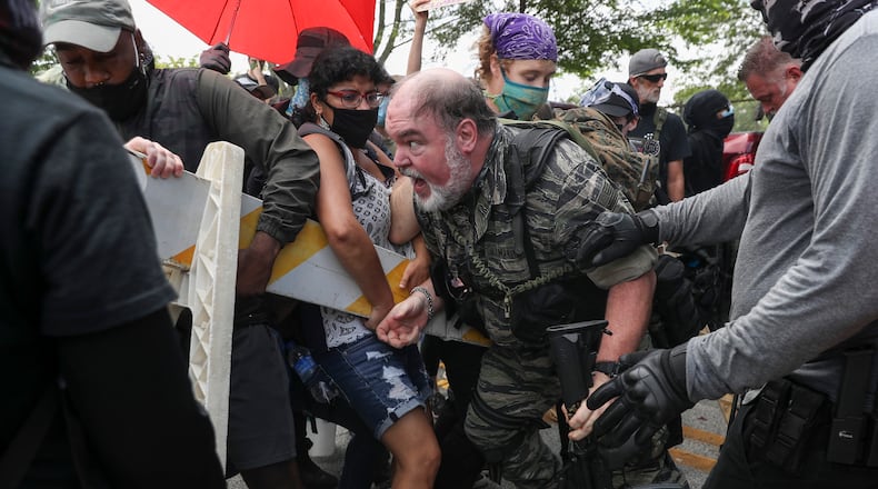 Protestors from both sides clash as several far-right groups, including militias and white supremacists, rally on Saturday, Aug. 15, 2020, in Stone Mountain, Georgia, while a broad coalition of leftist anti-racist groups organized a counter-demonstration there after local authorities closed Stone Mountain park. (Alyssa Pointer/Atlanta Journal-Constitution/TNS)