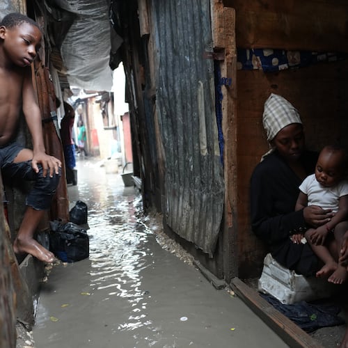 People stay inside a shelter for families displaced by gang violence, flooded by rain brought by Hurricane Melissa, in Port-au-Prince, Haiti, Wednesday, Oct. 29, 2025. (AP Photo/Odelyn Joseph)