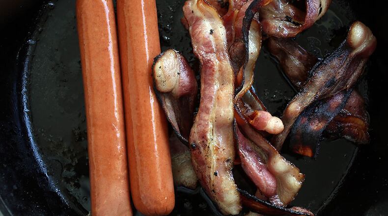 MIAMI, FL - OCTOBER 26: In this photo illustration, processed meats, including hotdogs and bacon, cook in a frying pan on October 26, 2015 in Miami, Florida. A report released today by the World Health Organisation's International Agency for Research on Cancer announced that eating processed meat can lead to colorectal cancer in humans even as it remains a small chance but rises with the amount consumed. (Photo illustration by Joe Raedle/Getty Images)