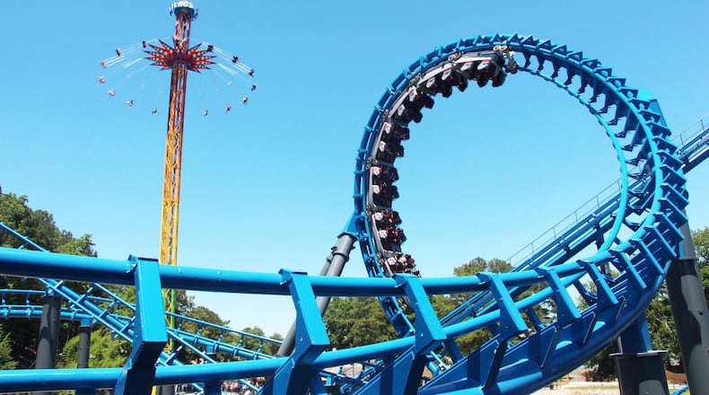 Riders tackle a loop on the Blue Hawk, a newly revamped version of the Ninja coaster, as the SkyScreamer looms in the background at Six Flags Over Georgia. CONTRIBUTED BY SIX FLAGS OVER GEORGIA