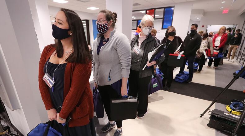 010521 LAWRENCEVILLE: Poll officials line up to turn in their election ballots at the Beauty P. Baldwin Voter Registrations and Elections Building on Tuesday night, Jan. 5, 2021, in Lawrenceville. Curtis Compton / Curtis.Compton@ajc.com”