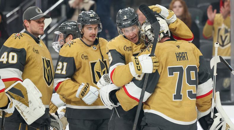 Vegas Golden Knights defenseman Brayden McNabb (3) and goaltender Carter Hart (79) hug after their shootout victory in an NHL hockey game against the Chicago Blackhawks Tuesday, Dec. 2, 2025, in Las Vegas. (AP Photo/Ian Maule)