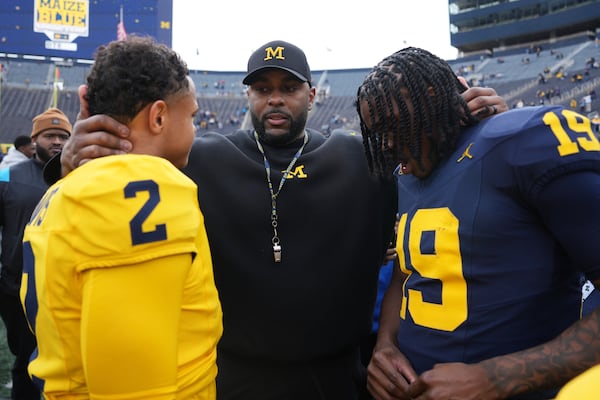 Michigan head coach Sherrone Moore, center, talks with quarterbacks Jadyn Davis (2) and Bryce Underwood (19) after an NCAA college football spring game in Ann Arbor, Mich., Saturday, April 19, 2025. (AP Photo/Paul Sancya)