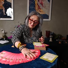 Healing practitioner Rolene Jaffe shows Rise & Radiate oracle cards, which Jaffe created, at 7th House, an astrological-themed restaurant where her son, Alexander Sher, is part owner, on Wednesday, April 1, 2026, in Atlanta. (Hyosub Shin/AJC)