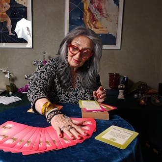 Healing practitioner Rolene Jaffe shows Rise & Radiate oracle cards, which Jaffe created, at 7th House, an astrological-themed restaurant where her son, Alexander Sher, is part owner, on Wednesday, April 1, 2026, in Atlanta. (Hyosub Shin/AJC)