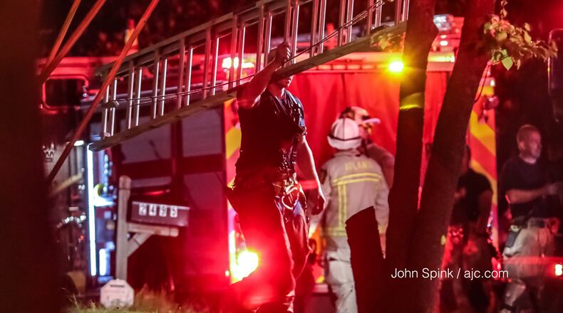 Crews with Atlanta Fire Rescue were on the scene of an early morning fire on Harvel Drive July 3. Investigators later determined that a man and his wife were strangled before their home caught fire. JOHN SPINK / JSPINK@AJC.COM