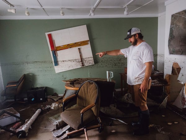 Garrett Burleson shows the damage to the office of his family's architectural business as a dirt line shows the extent of the flooding that the building faced, in Ingram on Friday July 4, 2025. (Christopher Lee/The San Antonio Express-News via AP)