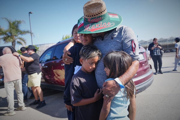 People embrace outside of Glass House Farms, a day after an immigration raid on the facility, on Friday, July 11, 2025, in Camarillo, Calif. (AP Photo/Damian Dovarganes)
