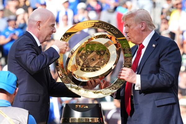 President Donald Trump, right, and FIFA President Gianni Infantino carry the championship trophy at the conclusion of the Club World Cup final soccer match at MetLife Stadium in East Rutherford, N.J., Sunday, July 13, 2025. (AP Photo/Jacquelyn Martin)