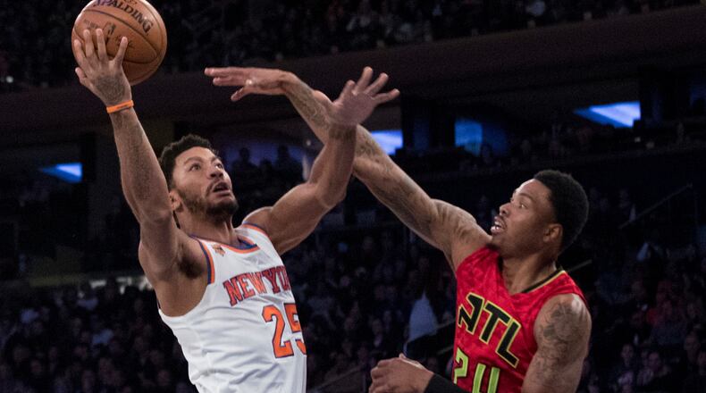 New York Knicks guard Derrick Rose (25) goes to the basket against Atlanta Hawks forward Kent Bazemore (24) and guard Tim Hardaway Jr. (10) during the first half of an NBA basketball game, Sunday, Nov. 20, 2016, at Madison Square Garden in New York. (AP Photo/Mary Altaffer)