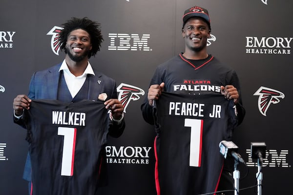 Atlanta Falcons first-round draft picks Jalon Walker, left and James Pearce Jr., right, hold up their jerseys during a news conference, Friday, April 25, 2025, in Flowery Branch, Ga. (AP Photo/Brynn Anderson)