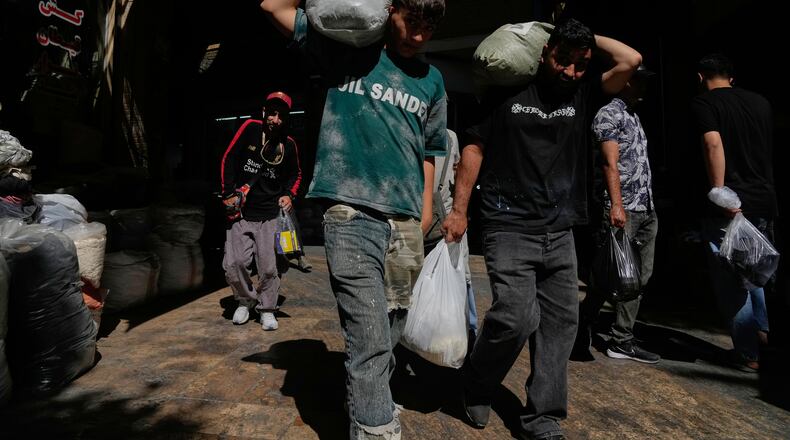 People carry packages at Tehran's historic Grand Bazaar, Iran, Monday, June 1, 2026. (AP Photo/Vahid Salemi)