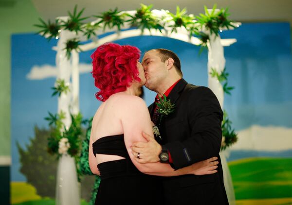 FILE - Natalie Rice, left, kisses her new husband, Lee Rice, beneath a canopy of faux marijuana plants during a ceremony at the Cannabis Chapel, Wednesday, April 20, 2016, in Las Vegas. (AP Photo/John Locher, File)