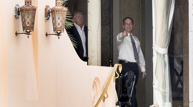President-elect Donald Trump, left, and Trump Chief of Staff Reince Priebus, right, walk along a balcony at Mar-a-Lago resort, in Palm Beach, Fla., Monday, Dec. 19, 2016. Trump is taking meetings today at the resort. (AP Photo/Andrew Harnik)