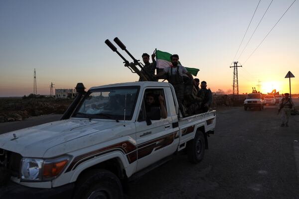 A convoy of government forces drives toward Sweida city where clashes erupted between government troops and Druze militias as it passes through Mazraa village in southern Syria, Tuesday, July 15, 2025. (AP Photo/Omar Albam)