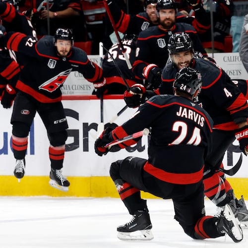 Carolina Hurricanes' Seth Jarvis (24) celebrates after his winning goal with Shayne Gostisbehere (4) during the overtime period in Game 2 of the NHL hockey Stanley Cup Final series against the Vegas Golden Knights in Raleigh, N.C., Thursday, June 4, 2026. (AP Photo/Karl DeBlaker)