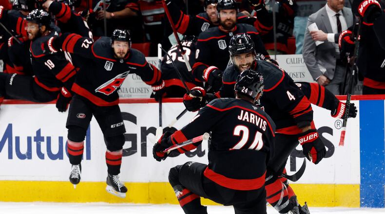 Carolina Hurricanes' Seth Jarvis (24) celebrates after his winning goal with Shayne Gostisbehere (4) during the overtime period in Game 2 of the NHL hockey Stanley Cup Final series against the Vegas Golden Knights in Raleigh, N.C., Thursday, June 4, 2026. (AP Photo/Karl DeBlaker)