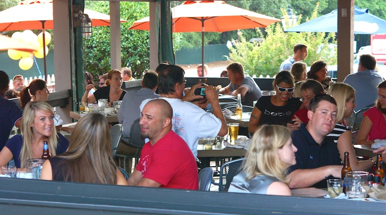People enjoying themselves outside on the Big Ketch Saltwater Grill's patio.