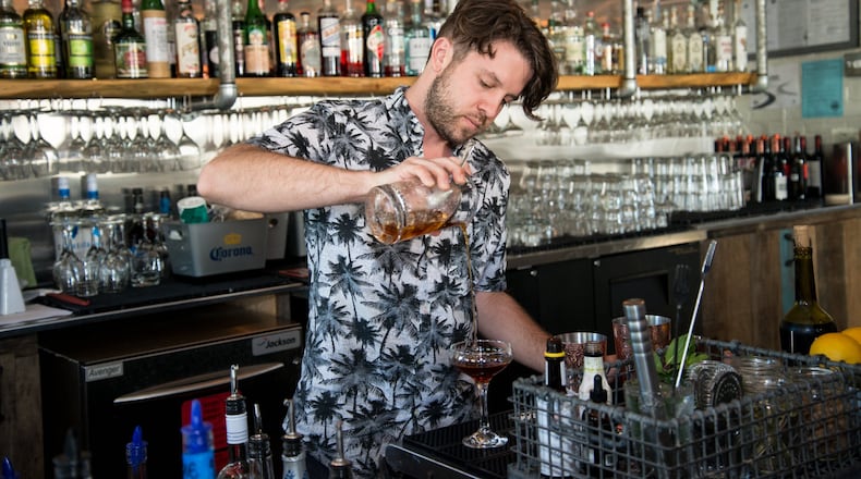 Jonathan Joy, beverage director of Bluetop, prepares the O Ducks Given cocktail. It is one of a handful of beverages on the menu made with meat-infused alcohol. Putting to use the kitchen’s excess rendered meat fat is one way that the restaurant strives to be more sustainable and reduce its kitchen waste. Photo credit - Mia Yakel.