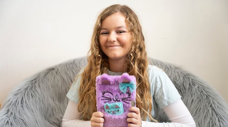 Alaya Horne, age 12, displays her journals that she used to chronicle the ups and downs of everyday life throughout the pandemic in simple but poignant terms: “These are some CRAZY times," in her home in Johns Creek Georgia on Wednesday, Nov. 22, 2023. (Olivia Bowdoin for the AJC).