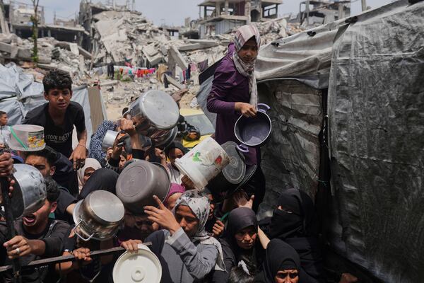 Palestinians struggle to get donated food at a community kitchen in Jabalia, northern Gaza Strip, Thursday, May 15, 2025. (AP Photo/Jehad Alshrafi)
