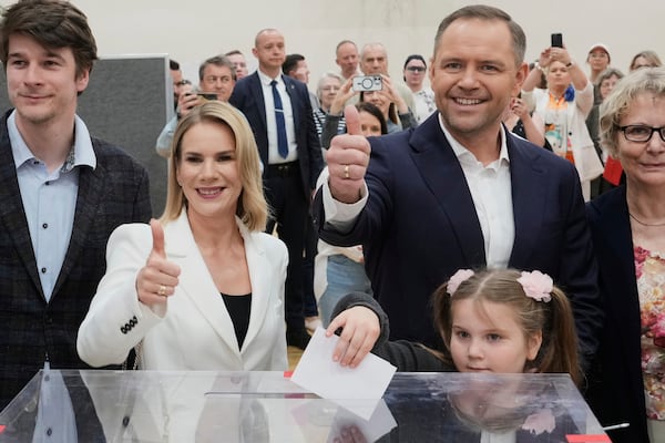 Presidential candidate Karol Nawrocki, second right, poses with his wife Marta Nawrocka, second left, and daughter Katarzyna at a polling station during the presidential election runoff in Warsaw, Poland, Sunday, June 1, 2025. (AP Photo/Czarek Sokolowski)
