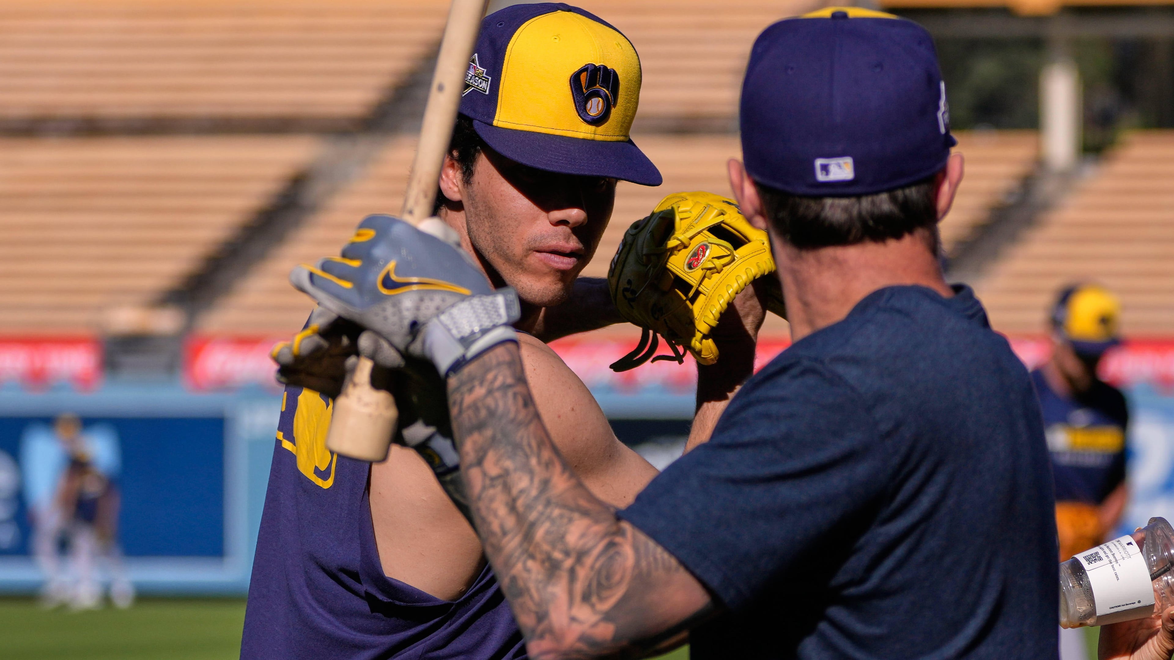 Milwaukee Brewers' Christian Yelich, left, and Brice Turang warm up during practice ahead of Game 3 of baseball's National League Championship Series against the Los Angeles Dodgers, Wednesday, Oct. 15, 2025, in Los Angeles. (AP Photo/Mark J. Terrill)