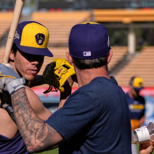 Milwaukee Brewers' Christian Yelich, left, and Brice Turang warm up during practice ahead of Game 3 of baseball's National League Championship Series against the Los Angeles Dodgers, Wednesday, Oct. 15, 2025, in Los Angeles. (AP Photo/Mark J. Terrill)
