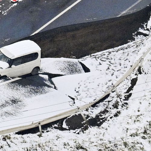 This aerial photo shows a vehicle sitting on a damaged road in Tohoku town, Aomori prefecture, northern Japan Tuesday, Dec. 9, 2025, following a powerful earthquake on late Monday. (Kyodo News via AP)